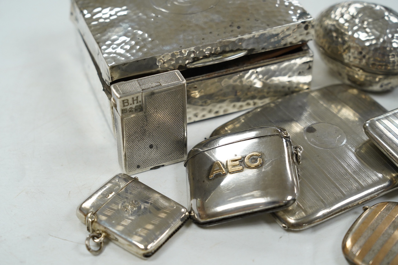 Eleven smoking related items including four silver vesta cases, one egg shaped, two silver ashtrays, two silver cigarette cases, a cigarette box, silver match sleeve and a silver plated Dunhill lighter. Condition - poor